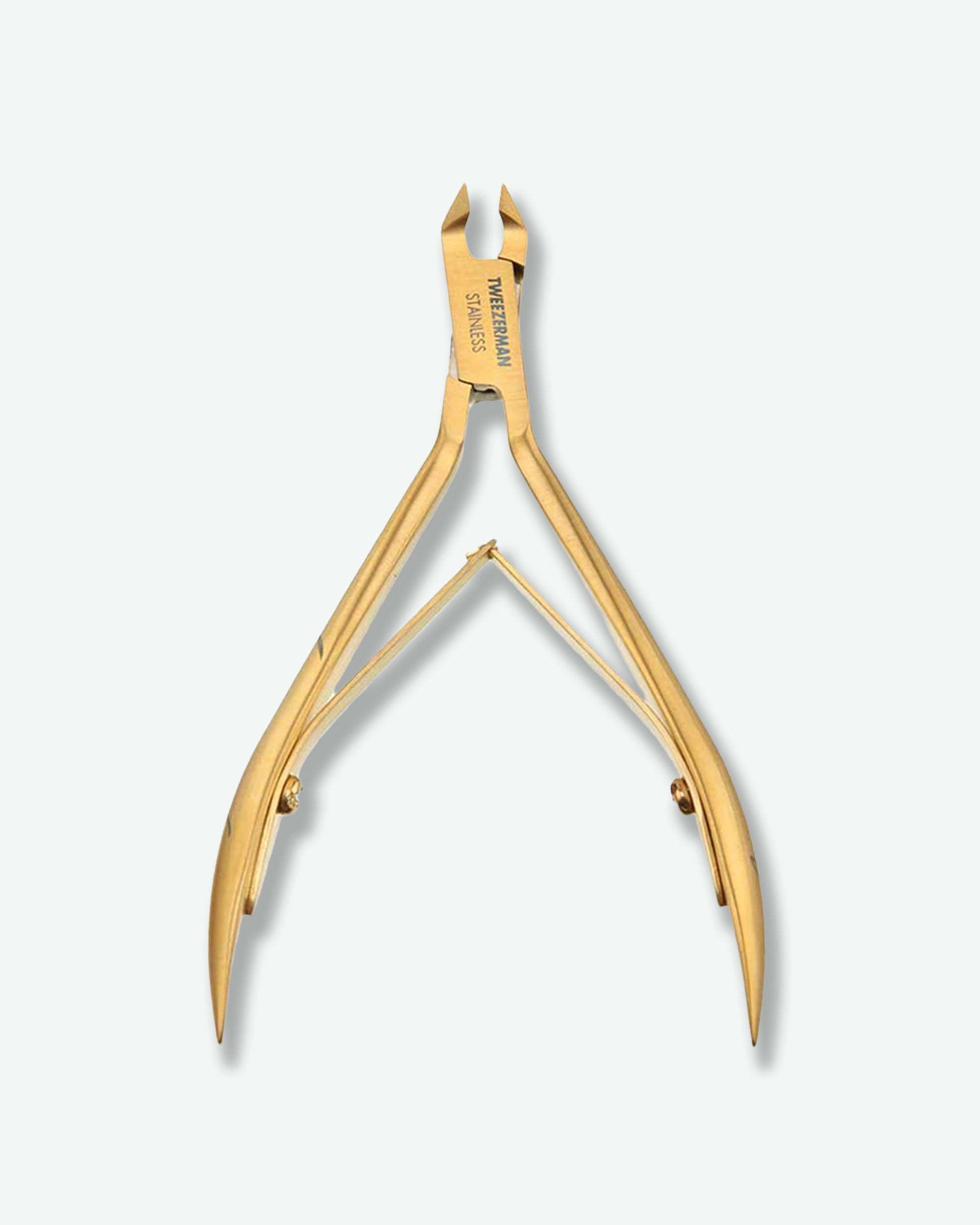 Front view of a pair of open Tweezerman cuticle nippers standing against a plain gray background. The precision manicure tool is crafted with a luxurious brushed gold metallic finish and is engraved with "TWEEZERMAN STAINLESS" on the joint.
