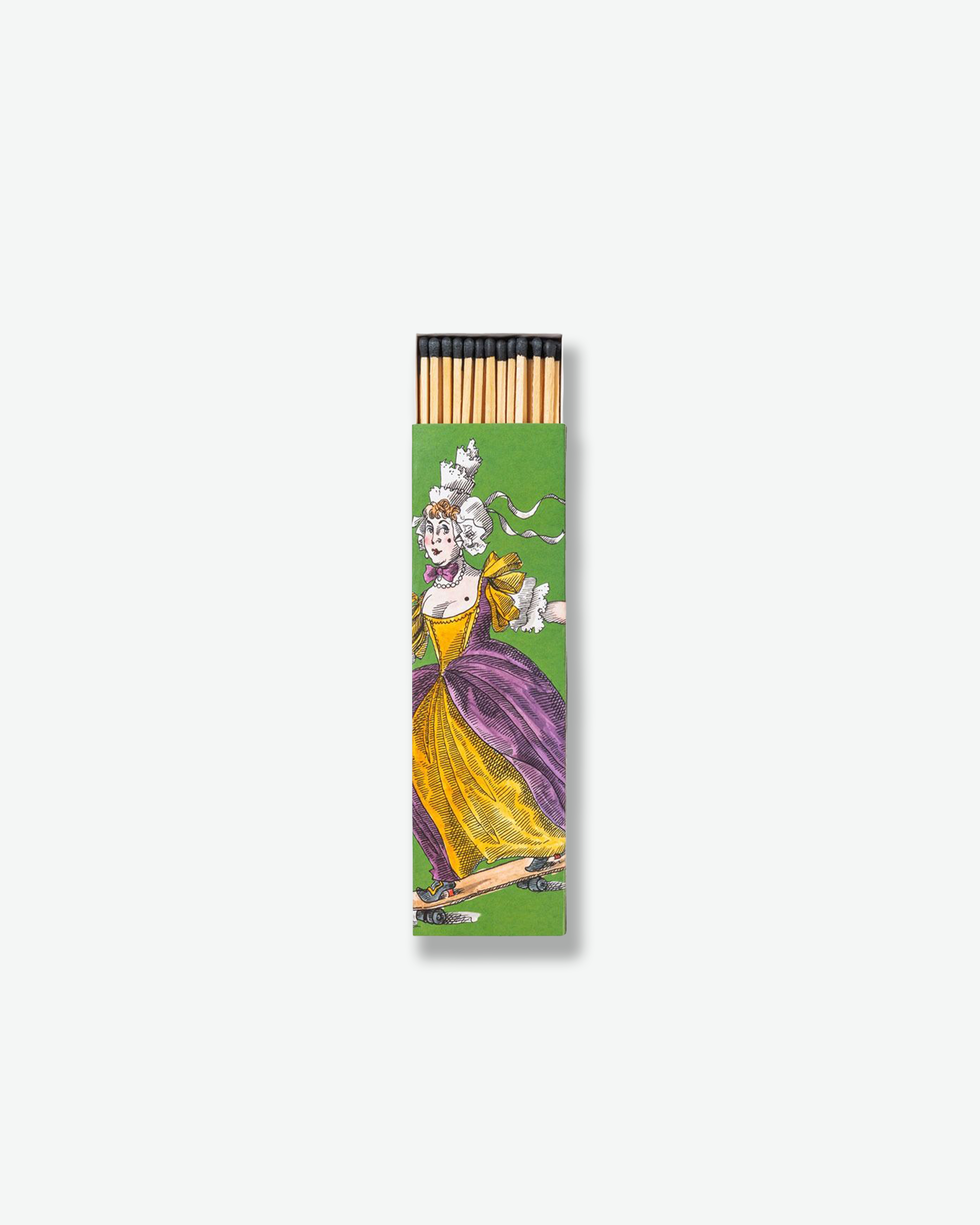 A green Trudon matchbox featuring an illustration of an 18th-century noblewoman wearing a powdered wig and a yellow and purple gown, riding a skateboard. Black-tipped wooden matches are visible sticking out from the top opening.