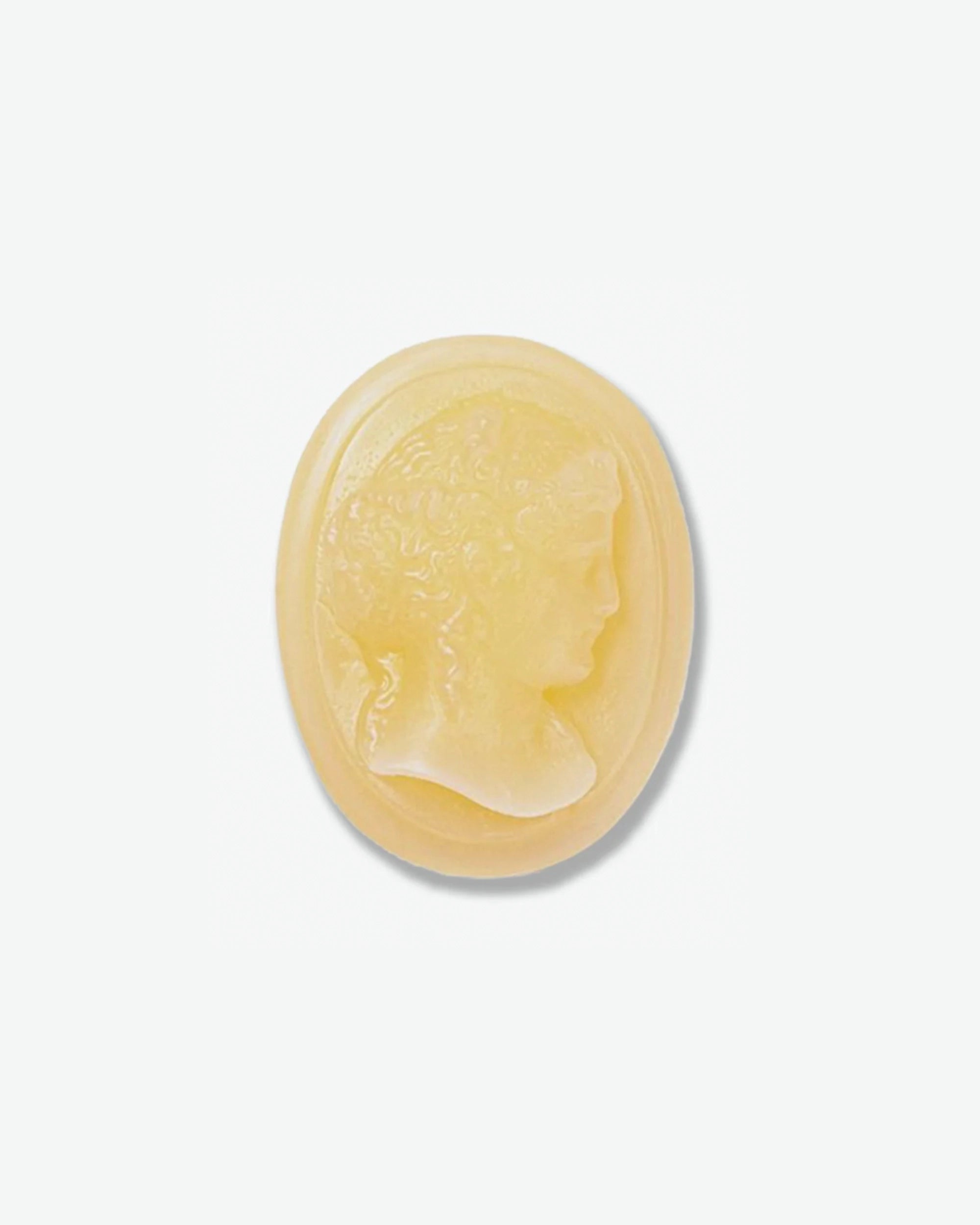 An oval-shaped, pale yellow cameo featuring a raised profile carving of a classical figure's head.
