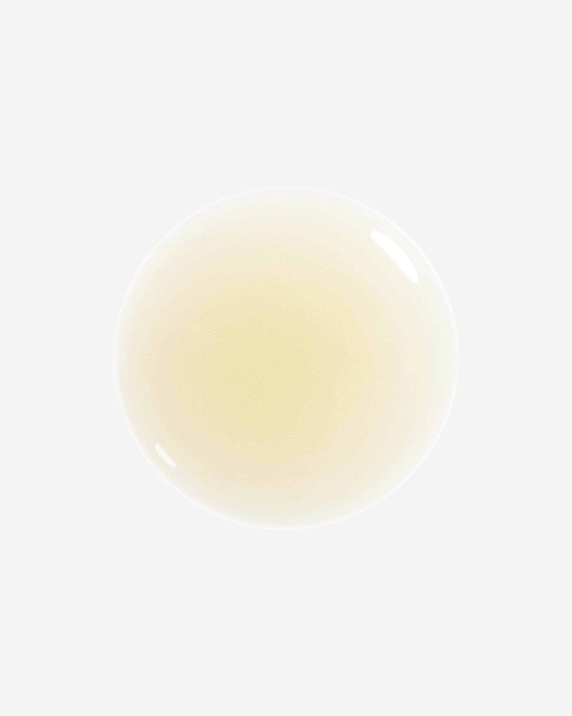 A translucent, pale yellow circular drop of liquid with a glossy reflection on a white background.