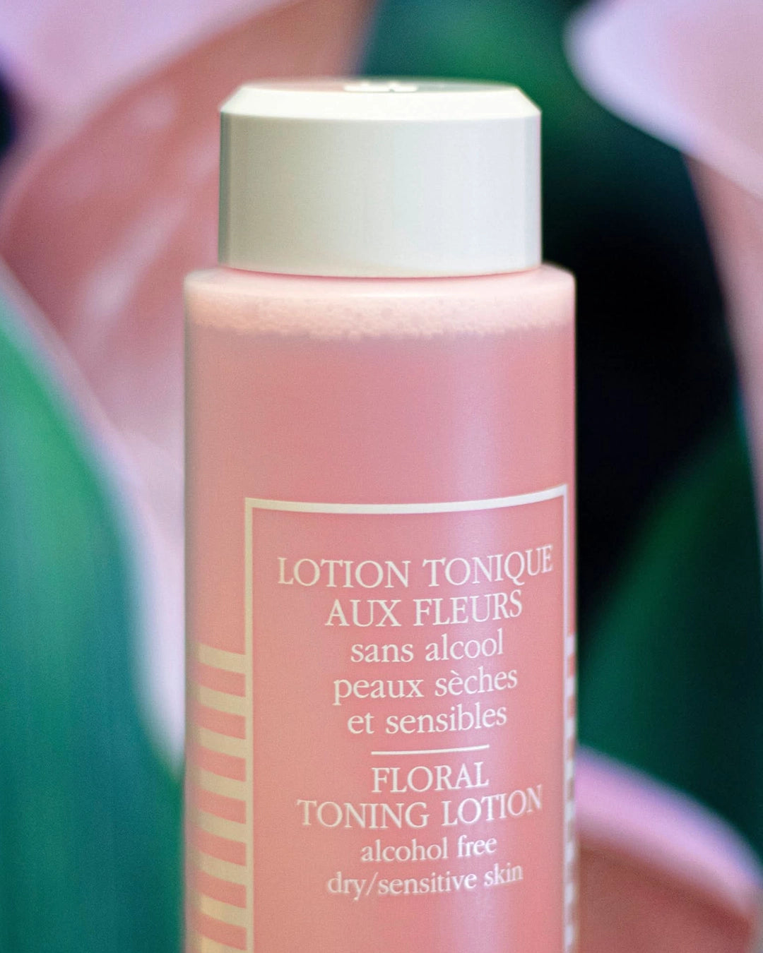 Floral toning lotion bottle with green blurred background