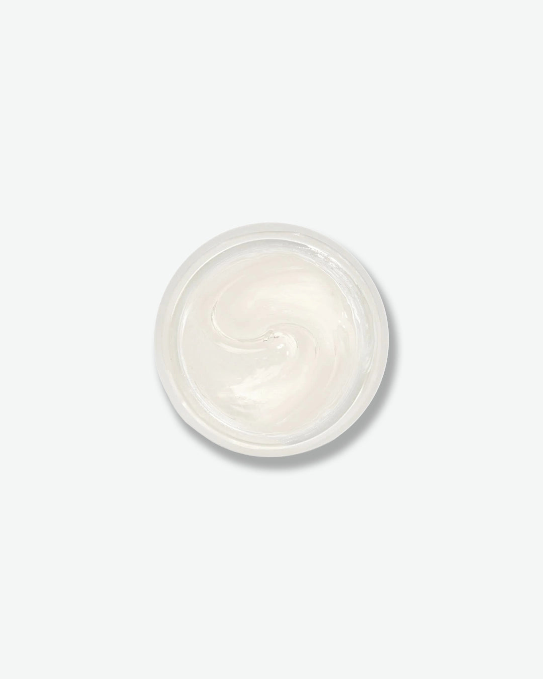 Small round container of white cream on a light gray background