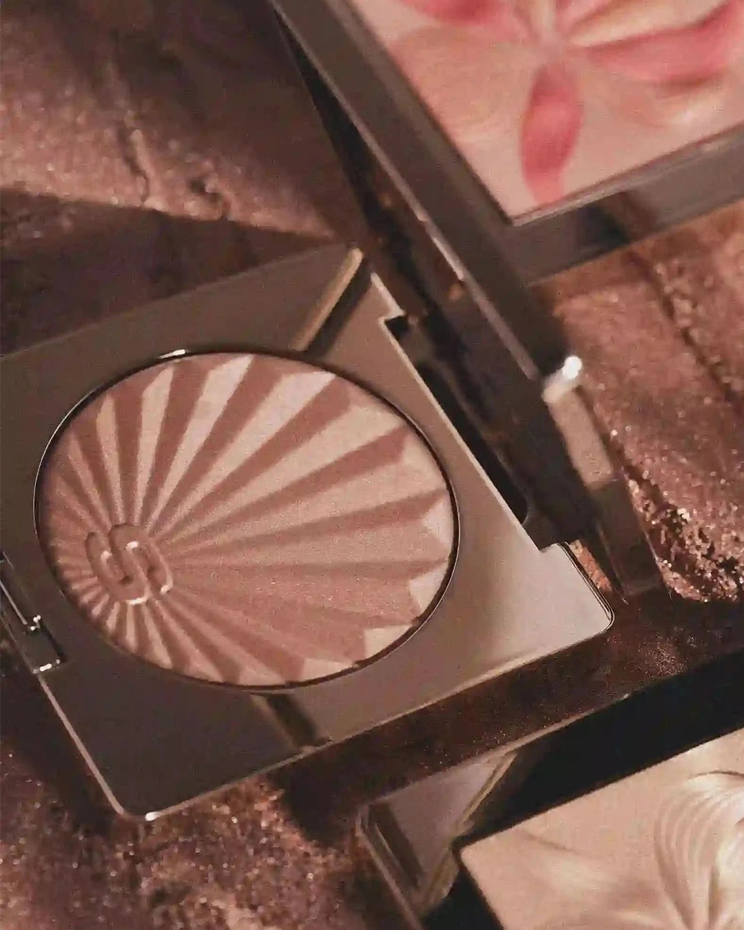 Makeup compact with pinkish nude blush shade on a textured surface