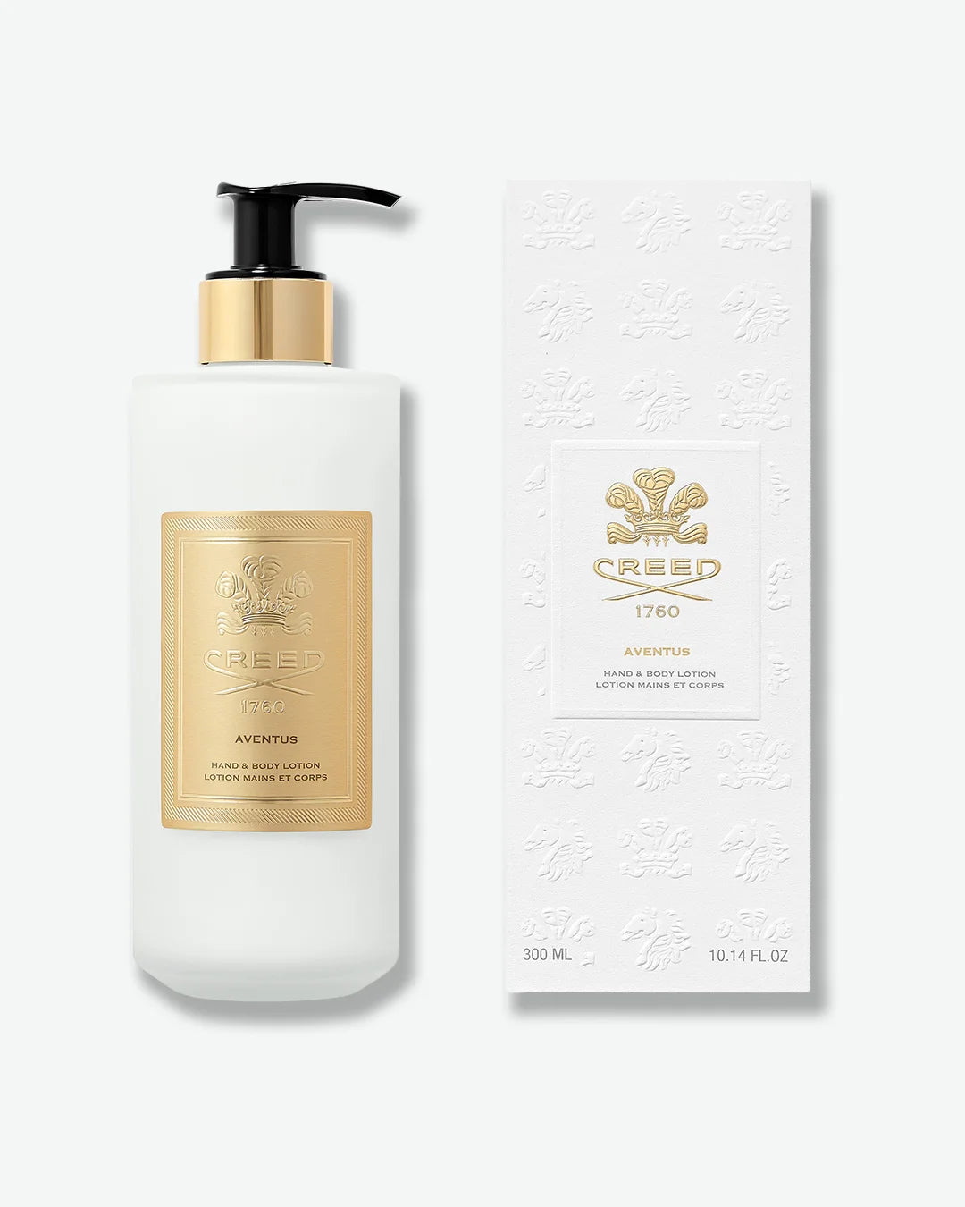 White Creed Aventus Hand & Body lotion bottle with black pump and gold label, stood next to the embossed white packaging box with gold lettering, on a white background