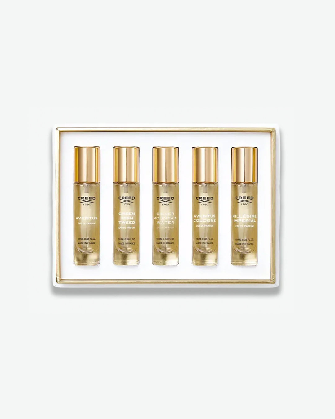 A Creed men's fragrance discovery set displaying five travel spray vials in a white box with a thin gold inner trim, featuring scents like Aventus, Green Irish Tweed, and Silver Mountain Water, isolated on a light grey background.