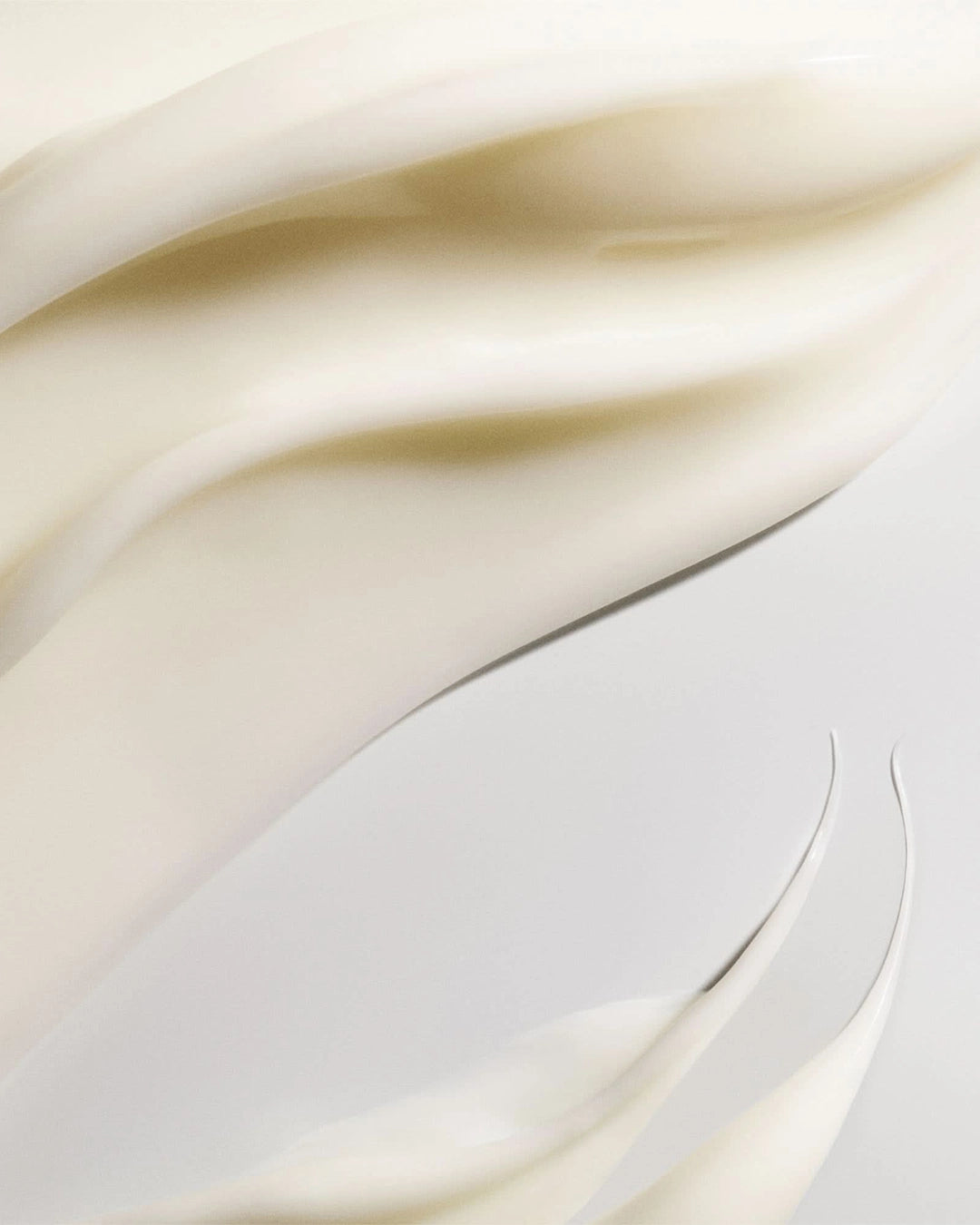 Close-up of smooth, beige cream with soft folds on a light background