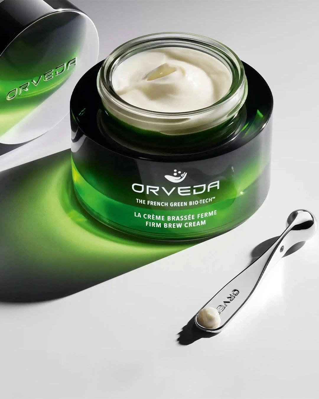 Orveda cream jar with a spoon on a gray background