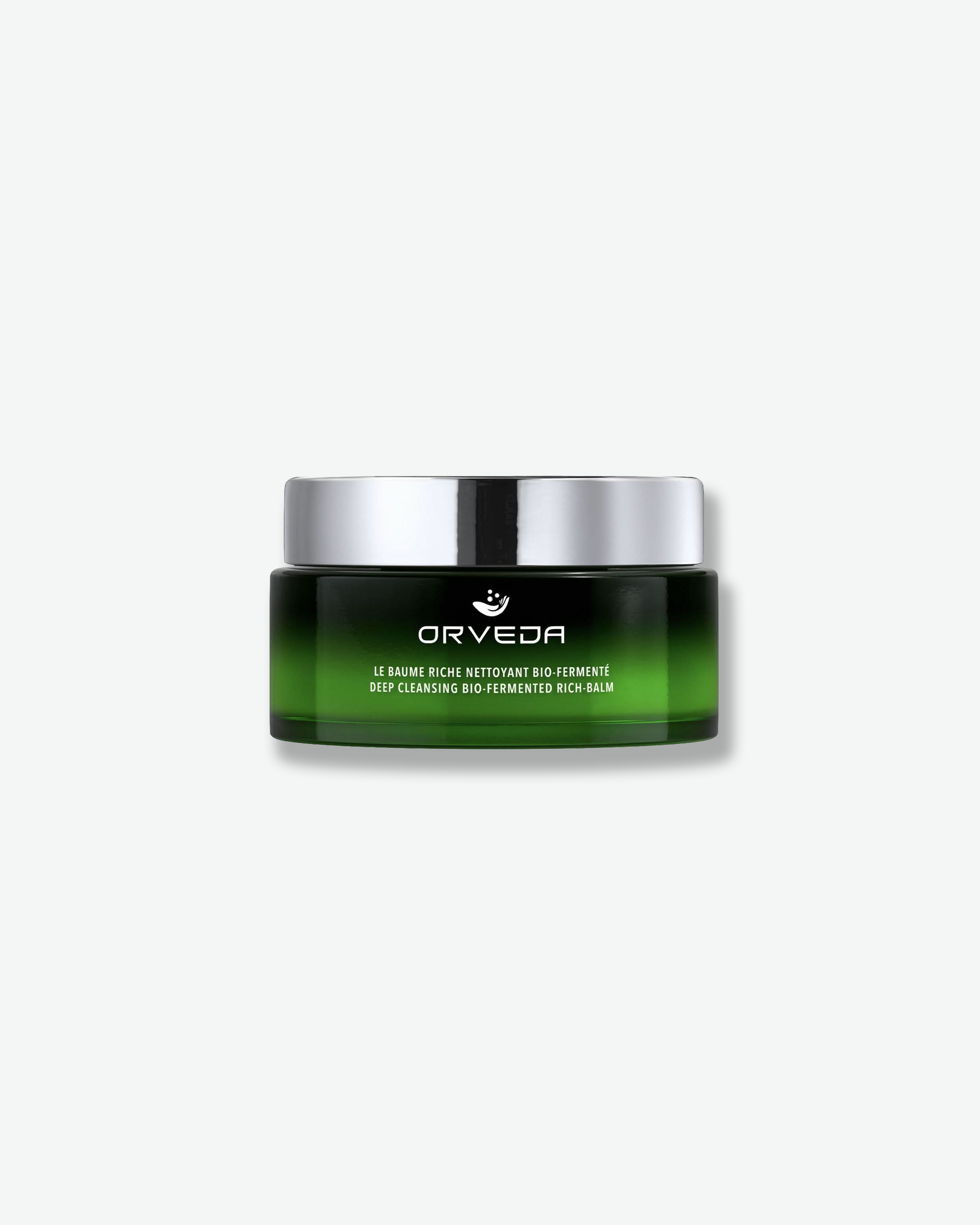 Front view of an Orveda "Deep Cleansing Bio-Fermented Rich-Balm" jar against a plain gray background. The low, wide glass container features a smooth dark-to-bright green ombre finish, minimal white branding text, and a highly polished silver metallic cap.