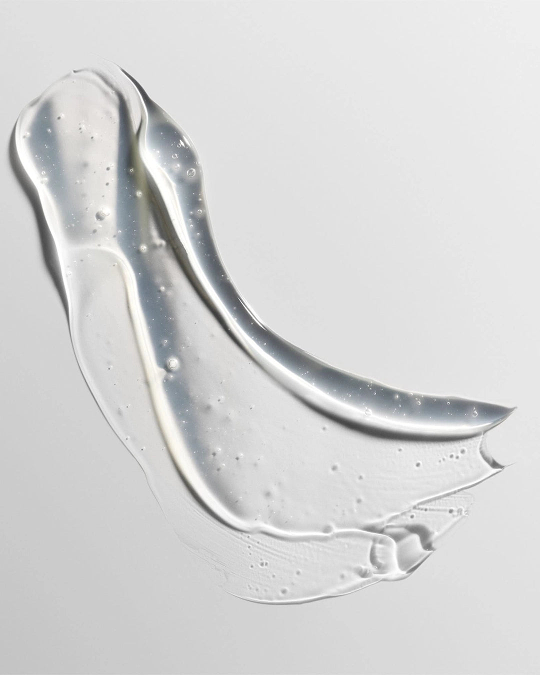 Clear gel or cream smear on a light gray background