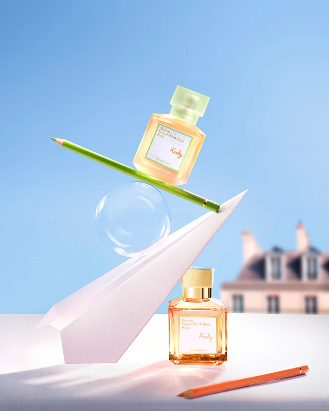 Two perfume bottles with a pencil on a light blue background