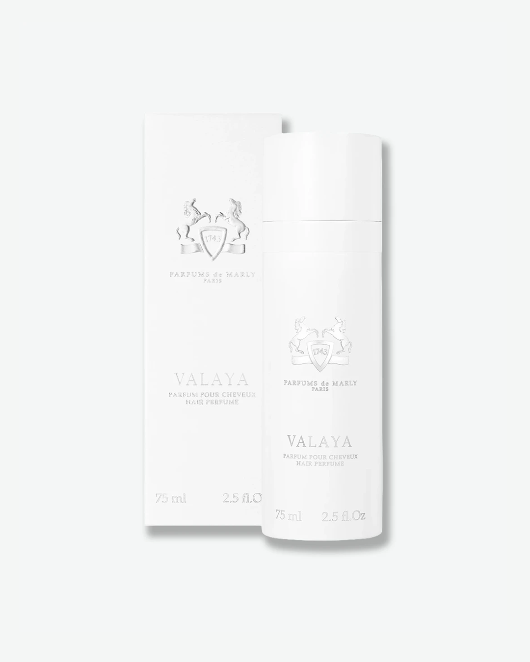 A product presentation shot showing the Parfums de Marly Valaya Hair Perfume bottle standing in front of its original white packaging box. Both the bottle and the box feature identical minimalist layouts with a silver embossed equestrian crest, brand branding, and the product name 'VALAYA HAIR PERFUME' set against a clean, monochromatic white backdrop.