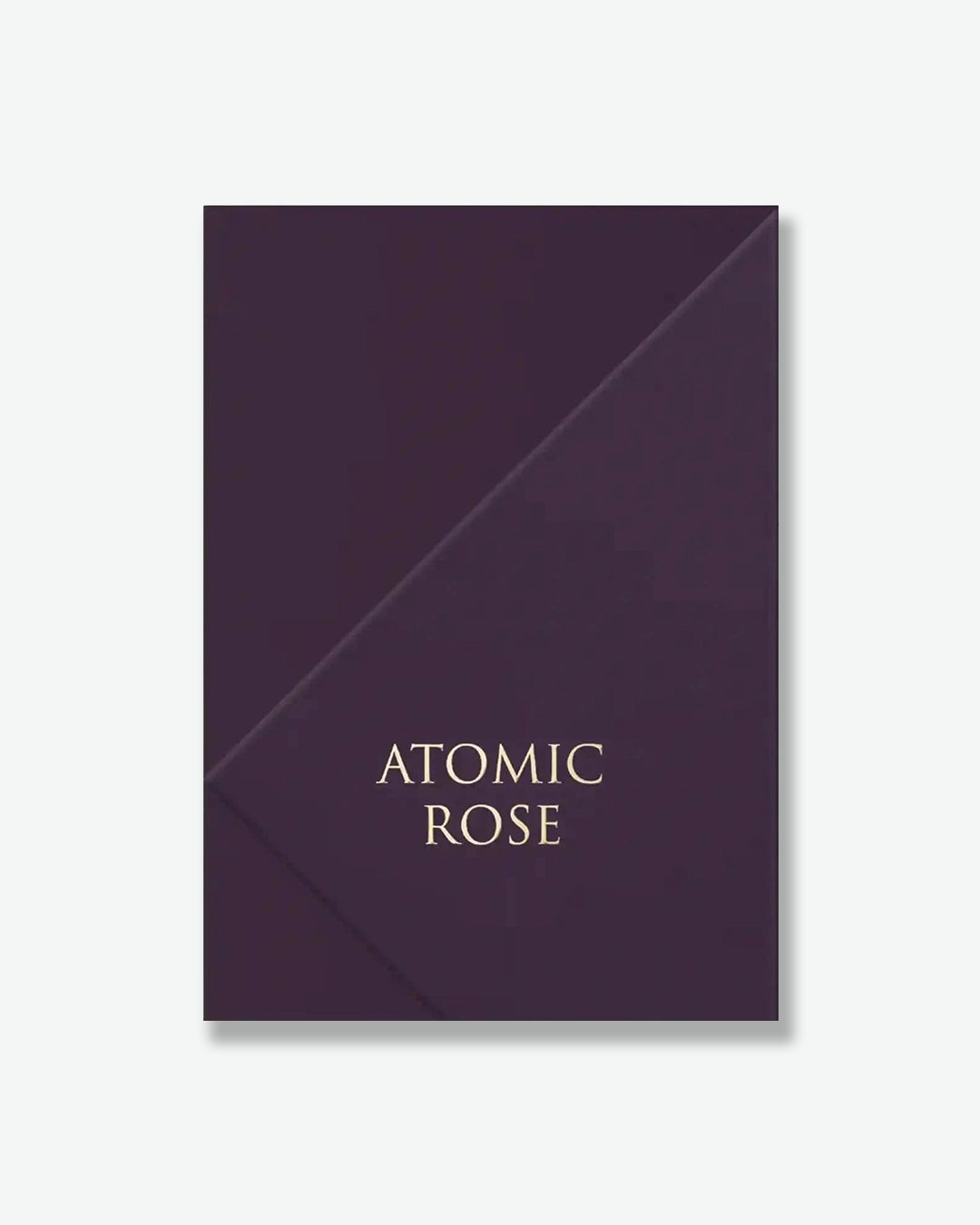 Dark purple product packaging with 'Atomic Rose' text on a white background