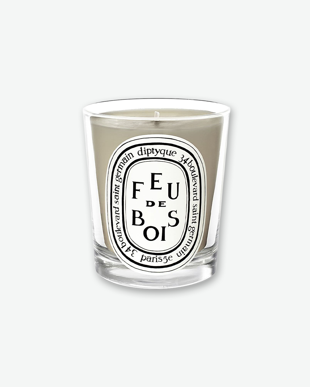 Front view of a Diptyque Feu de Bois scented candle. The candle features grey-colored wax inside a clear glass holder, complete with the signature oval white and black Diptyque label displaying stylized lettering for "Feu de Bois" and the "34 boulevard saint germain" address.