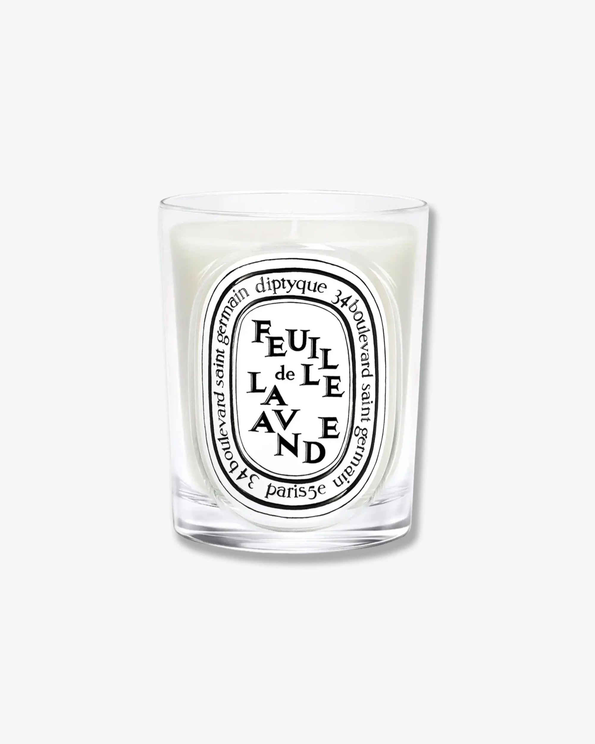Diptyque Feuille de Lavande scented candle in a classic clear glass jar featuring the signature white oval logo with black lettering, isolated on a light grey background.