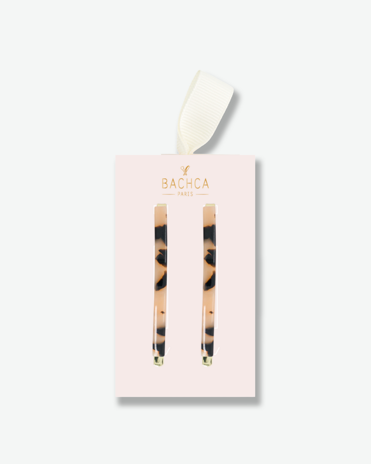 Set of two tortoiseshell hair clips with gold-tone accents, presented on a pale pink Bachca Paris gift card with an ivory ribbon.