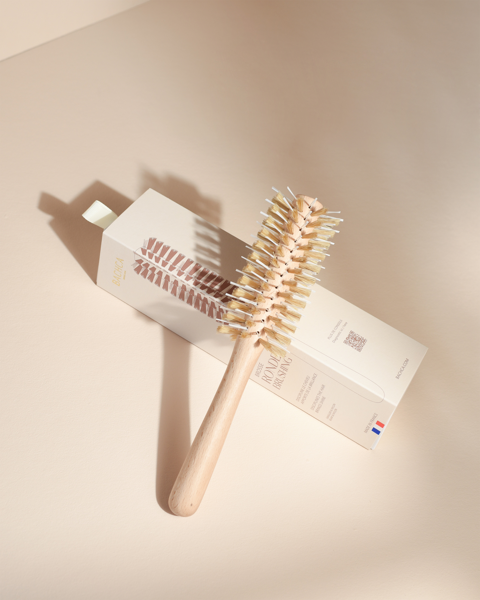 Hairbrush with a box on a beige background
