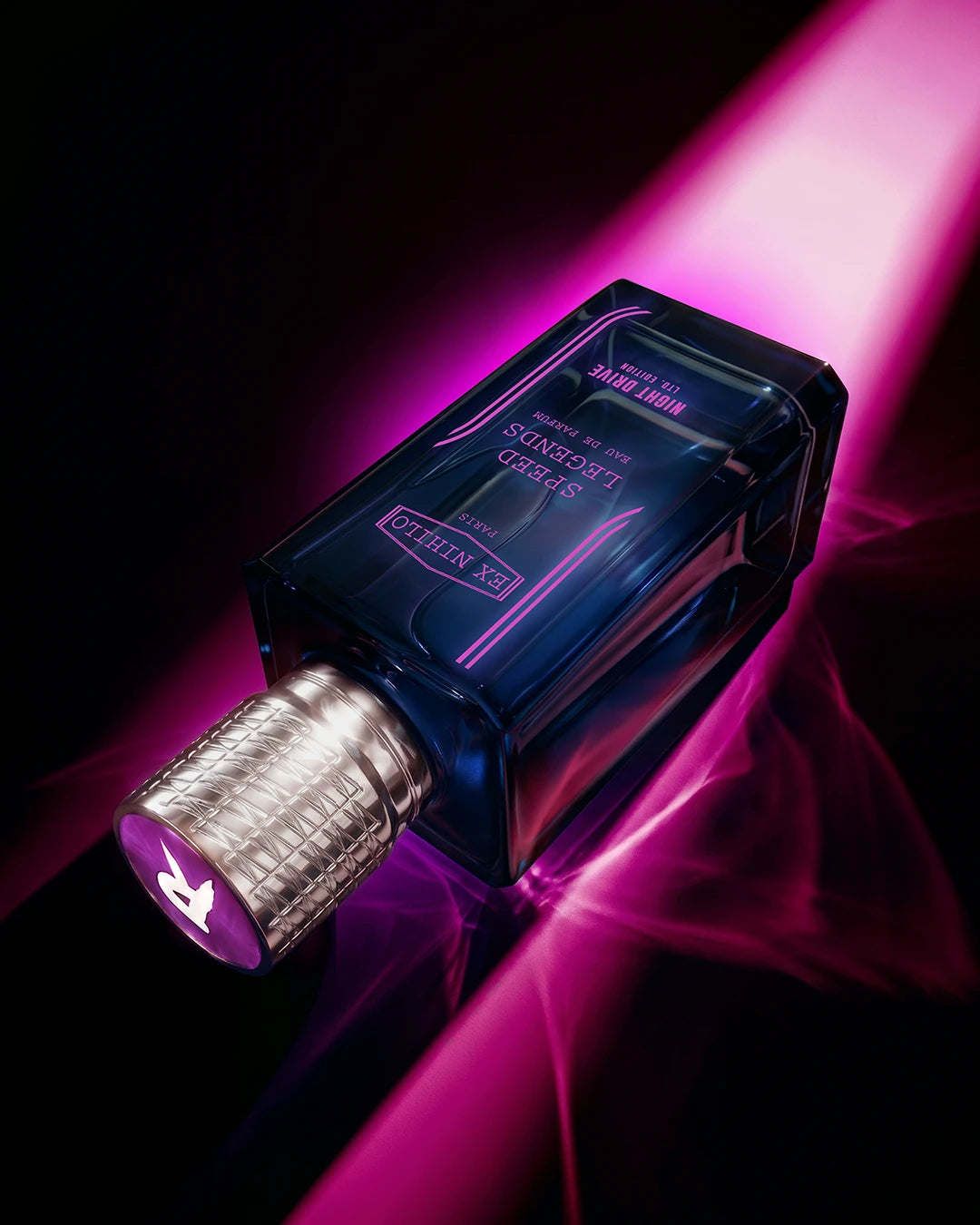Blue perfume bottle with silver cap on a dark background with pink light
