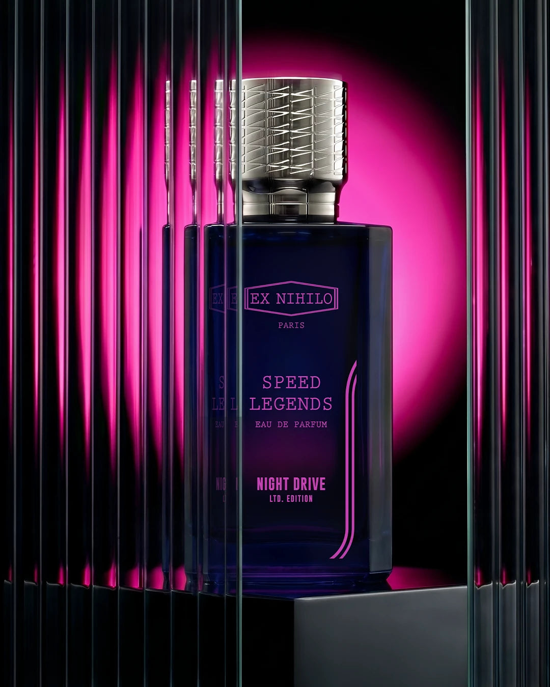 Blue perfume bottle with silver cap on a black and pink striped background
