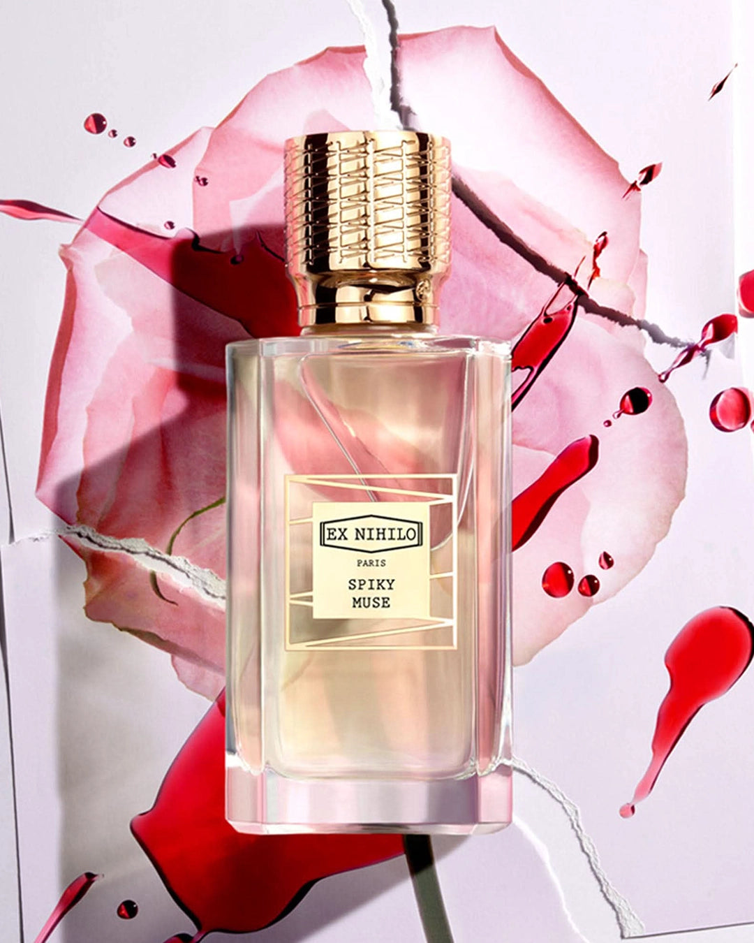 Perfume bottle labeled 'Ex Nihilo' with a floral and abstract design background