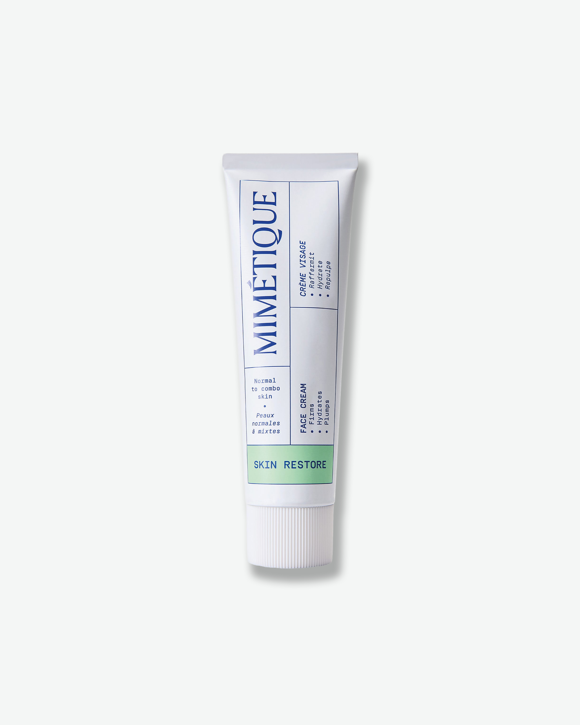A white squeeze tube of Mimétique Skin Restore facial cleanser, featuring blue text and a green accent band, set against a clean off-white background.