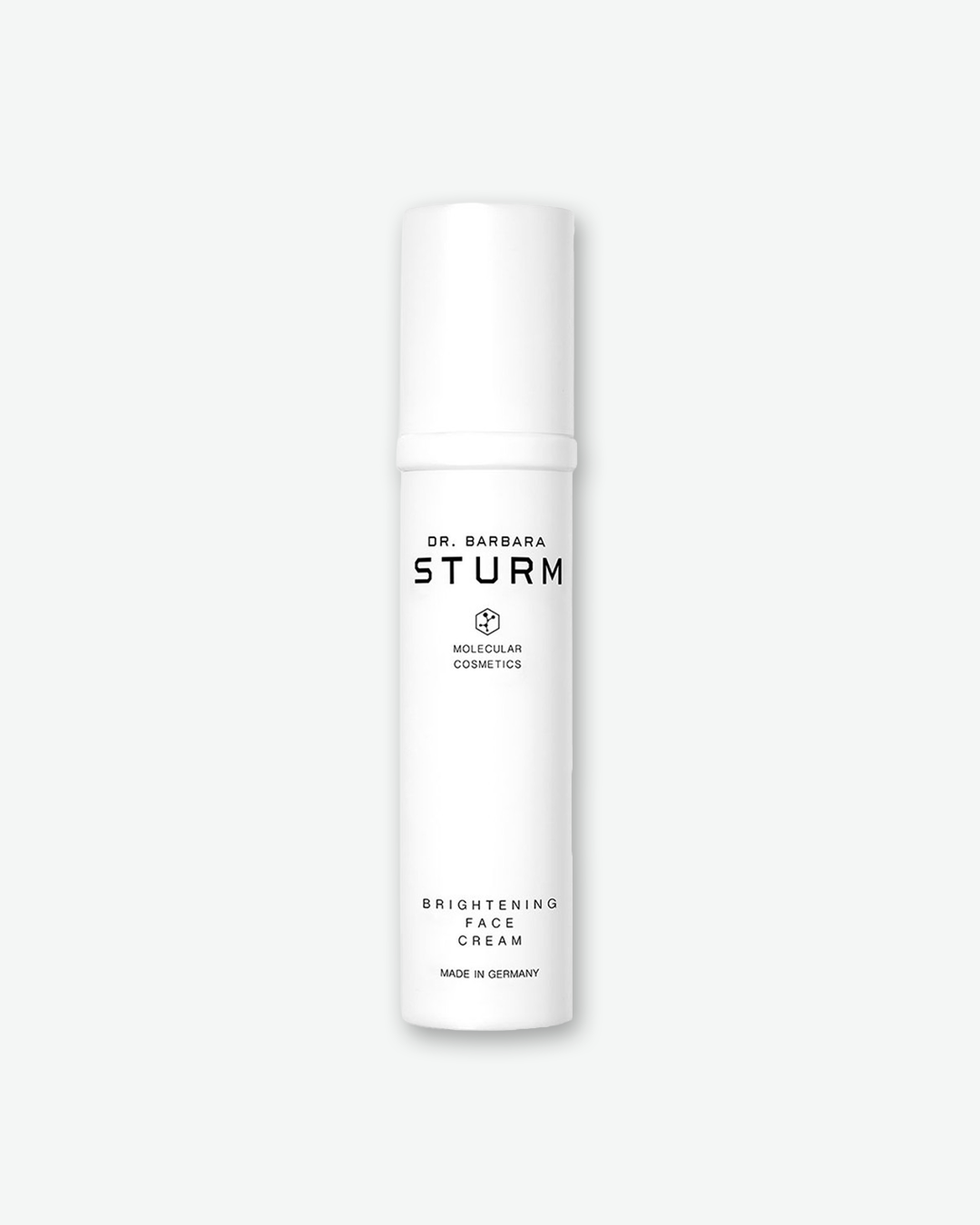 A product shot of a Dr. Barbara Sturm Brightening Face Cream bottle, centered against a light gray background. The sleek, slender cylindrical bottle is solid white with a matching opaque pump cap. The clean black text on the front reads "DR. BARBARA STURM", the molecular hexagon logo, "BRIGHTENING FACE CREAM", and "MADE IN GERMANY".