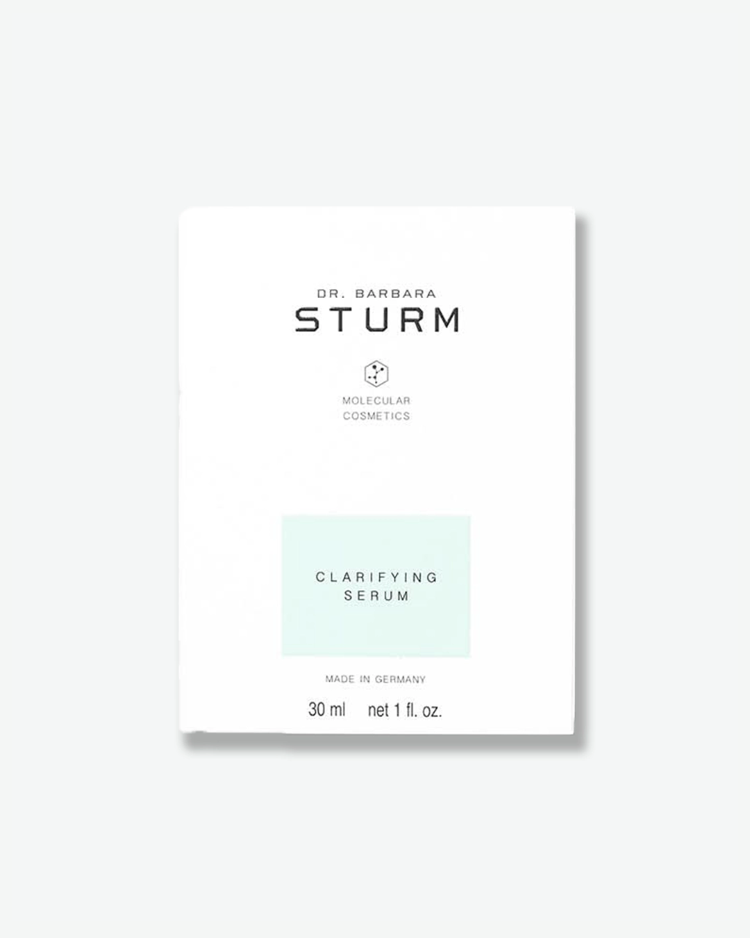 A product shot of the white cardboard box for Dr. Barbara Sturm Clarifying Serum, centered against a light gray background. The minimalist outer packaging features clean black branding text and a small molecular hexagon logo. A pastel, mint-green rectangle highlights the product name "CLARIFYING SERUM" in the lower center. The bottom notation reads "MADE IN GERMANY" above the volume "30 ml net 1 fl. oz."