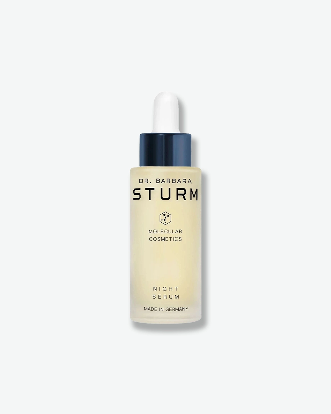 A product shot of a Dr. Barbara Sturm Night Serum bottle, centered on a light gray background. The frosted glass bottle reveals a pale yellowish liquid inside and is uniquely fitted with a dark metallic blue dropper cap and a white rubber bulb. The black text on the front reads "NIGHT SERUM" and "MADE IN GERMANY".