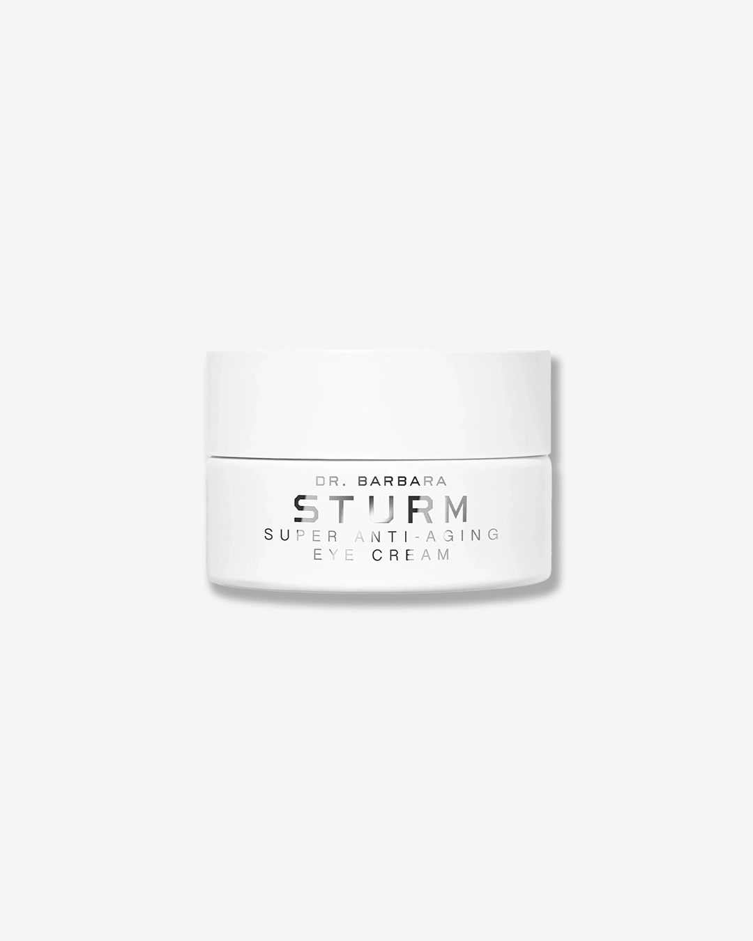 A product shot of a Dr. Barbara Sturm Super Anti-Aging Eye Cream jar, centered against a plain light gray background. The low, wide cylindrical jar is solid white with a matching flat screw cap. The front text reads "DR. BARBARA STURM", "SUPER ANTI-AGING", and "EYE CREAM" in clean black font.