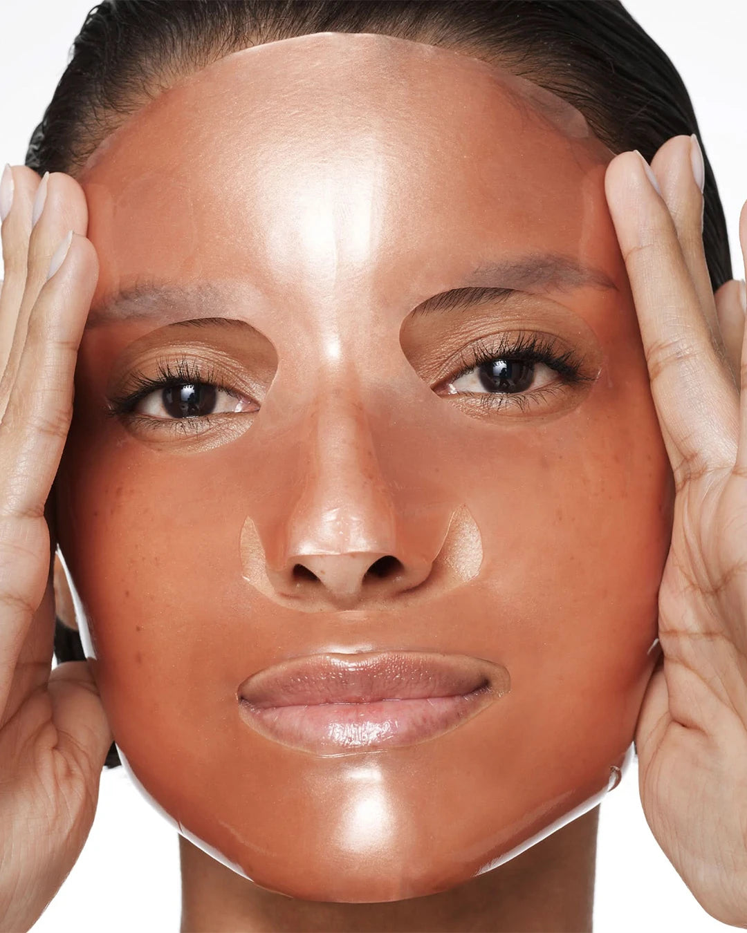 Close-up of a person's face with hands on either side, showing a neutral expression.