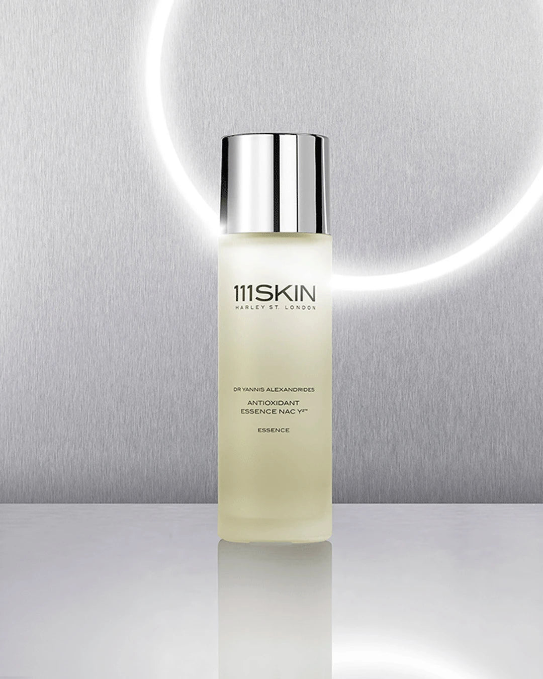 Skincare bottle labeled '111SKIN' on a reflective surface with a neutral background