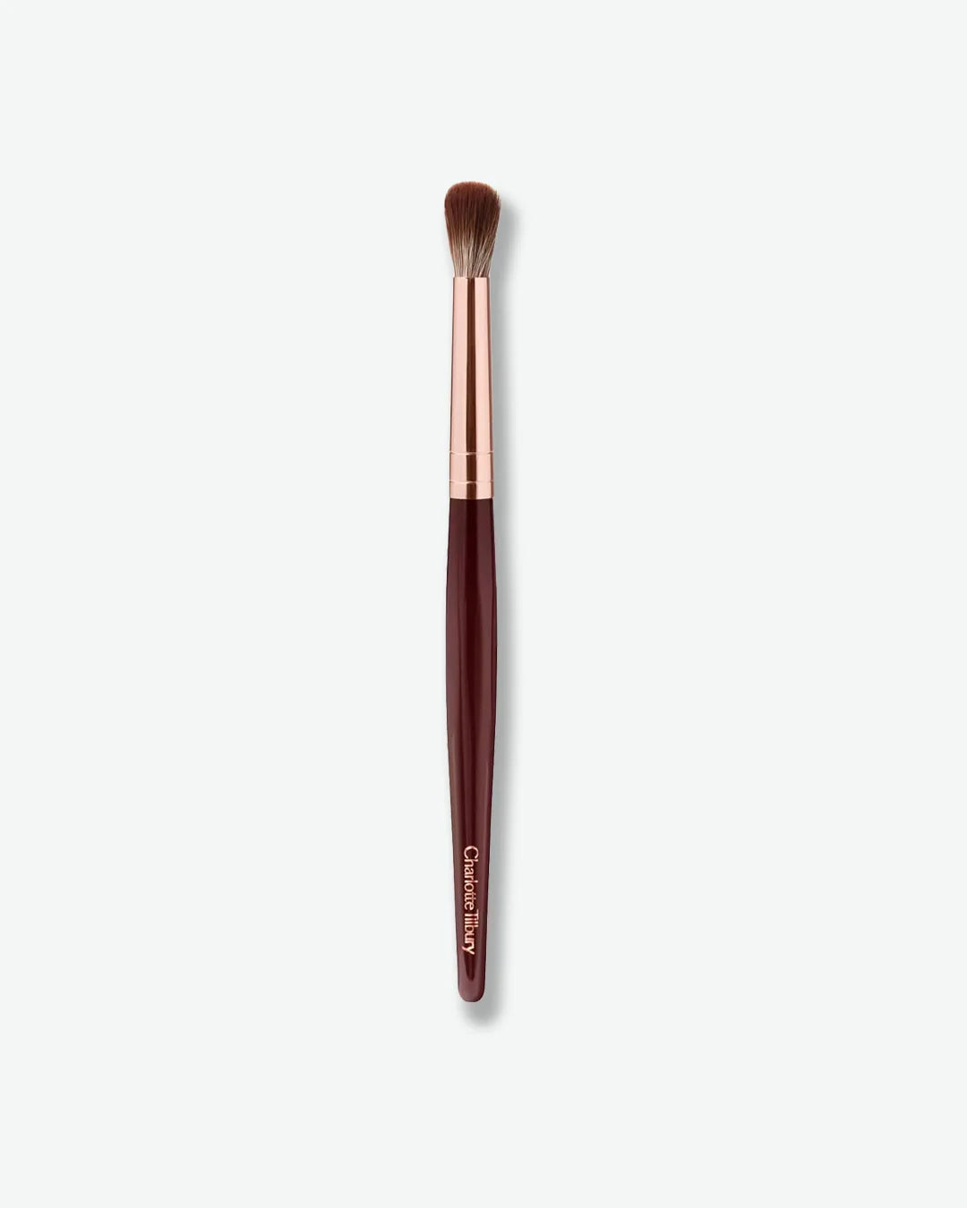 Makeup brush with rose gold and brown handle on a white background