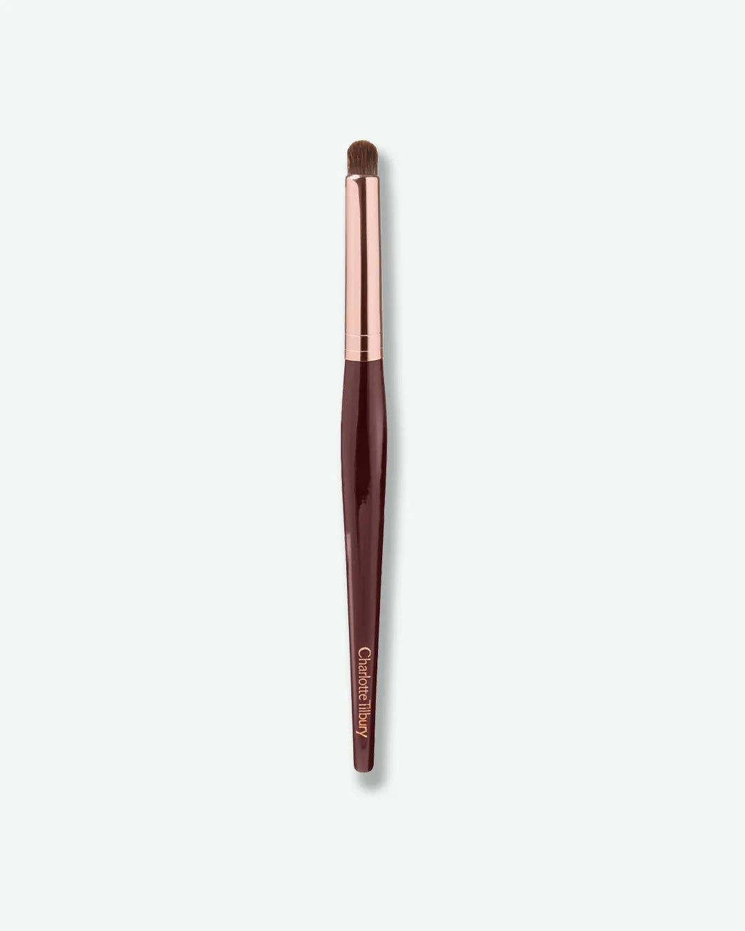 Makeup brush with rose gold ferrule and brown handle on a white background