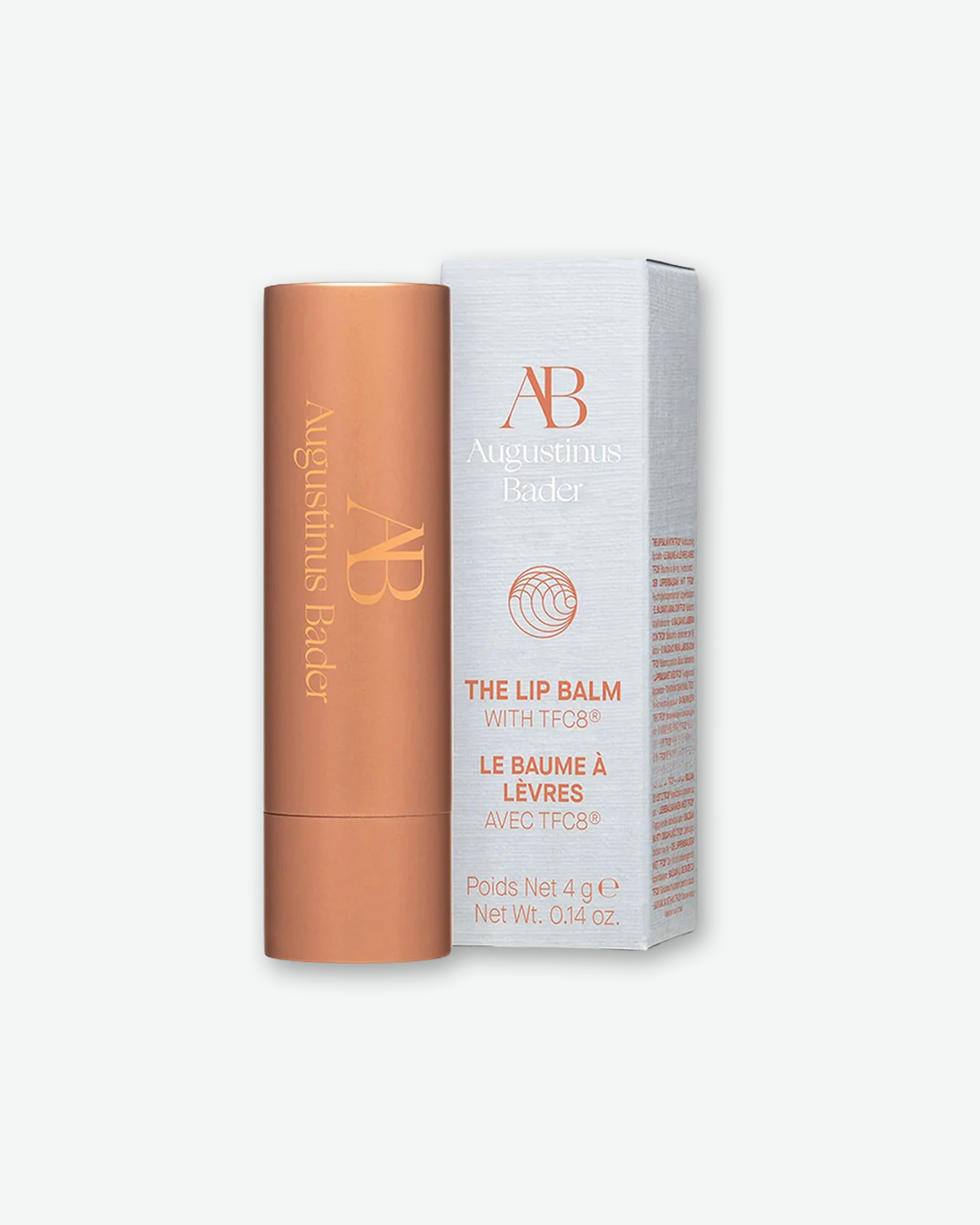 Augustinus Bader The Lip Balm 4g (0.14 oz.) in its metallic copper tube, standing next to its white and copper outer product box.