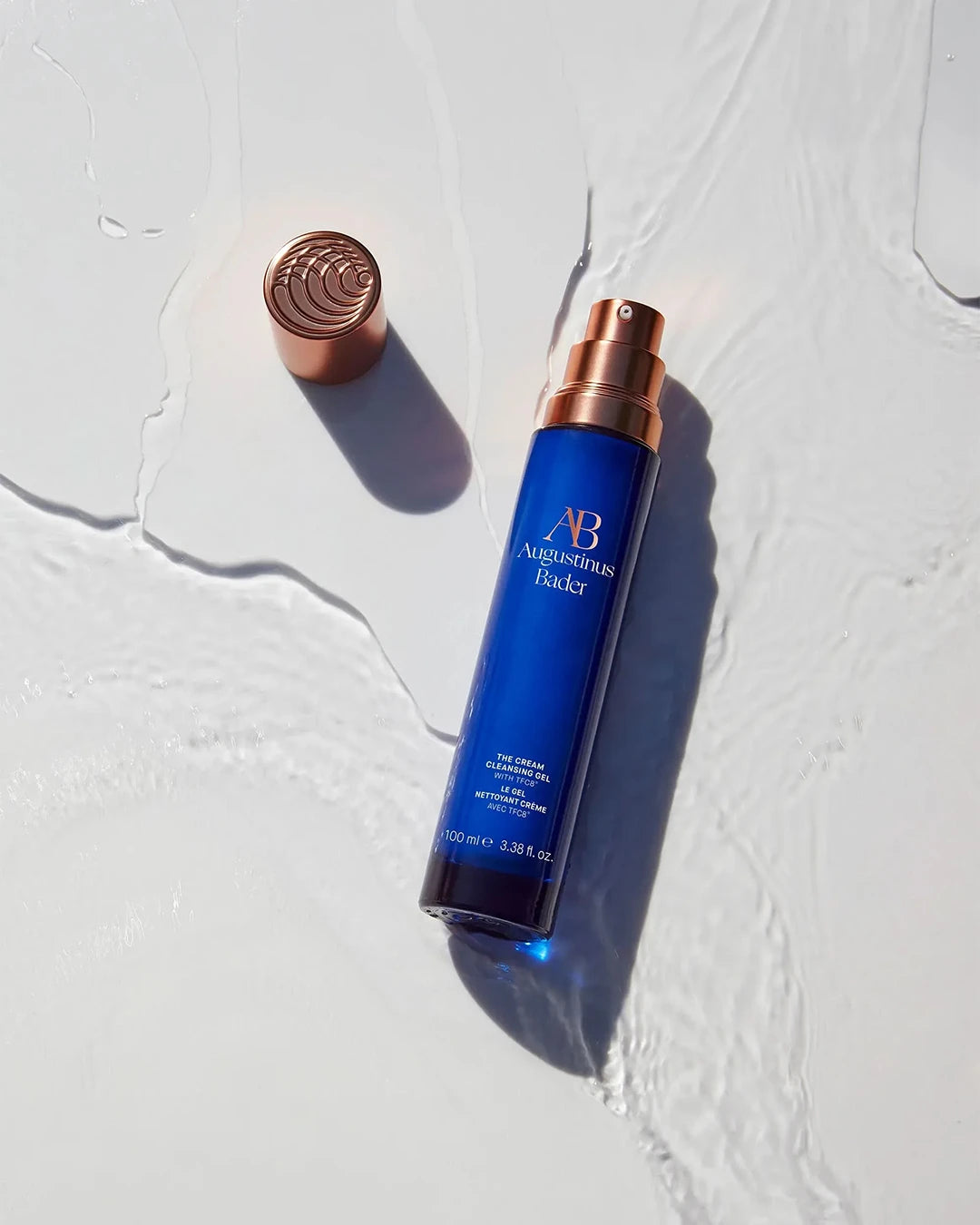Blue bottle with copper cap on a textured white background