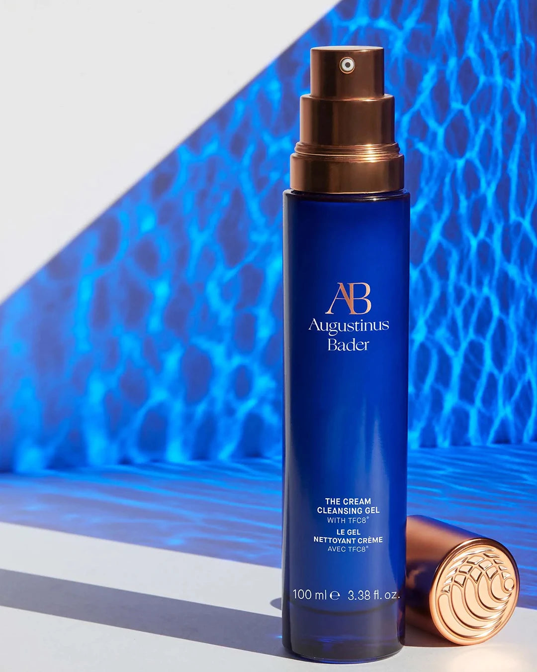 Blue skincare bottle with gold cap on a blue textured background