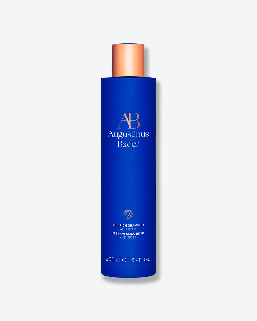 Augustinus Bader The Rich Shampoo in a sleek royal blue 200 mL bottle with a metallic copper-bronze cap, isolated on a clean white background.