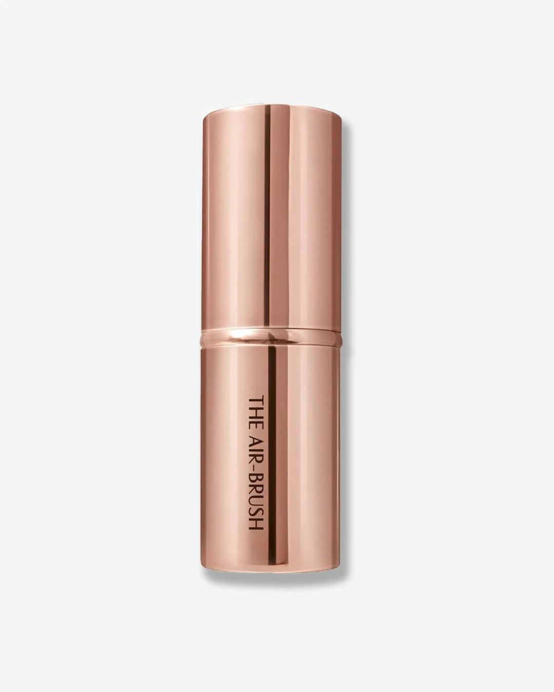 Rose gold makeup brush with cap and 'The Air-Brush' written on the tube on a light beige background