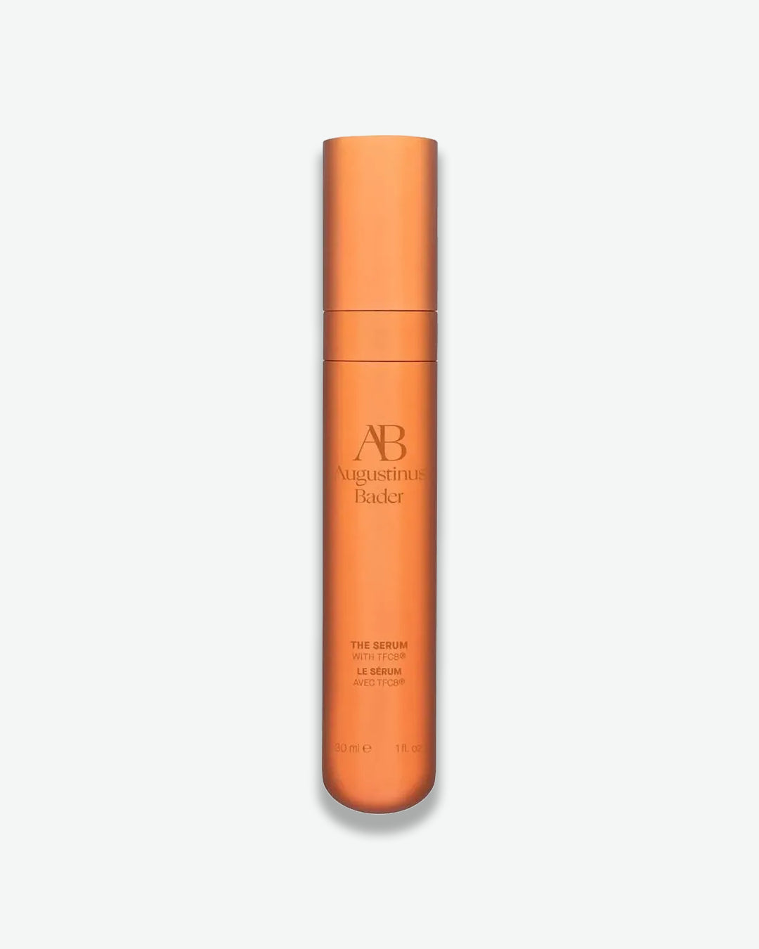 Orange skincare serum bottle with brand name on a light gray background