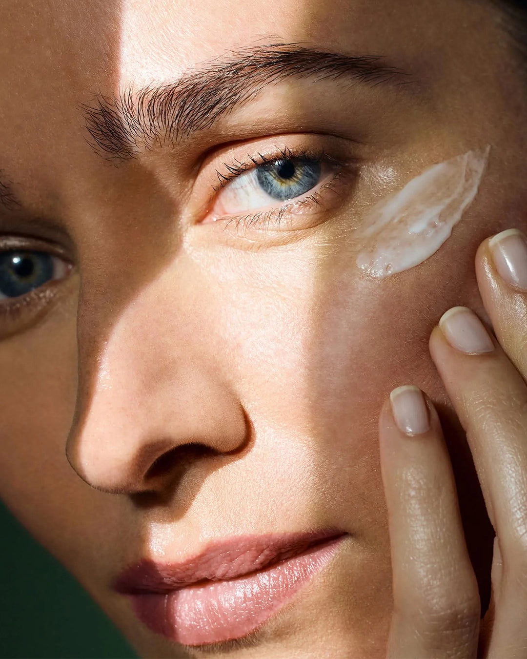 Close-up of a person applying cream to their face