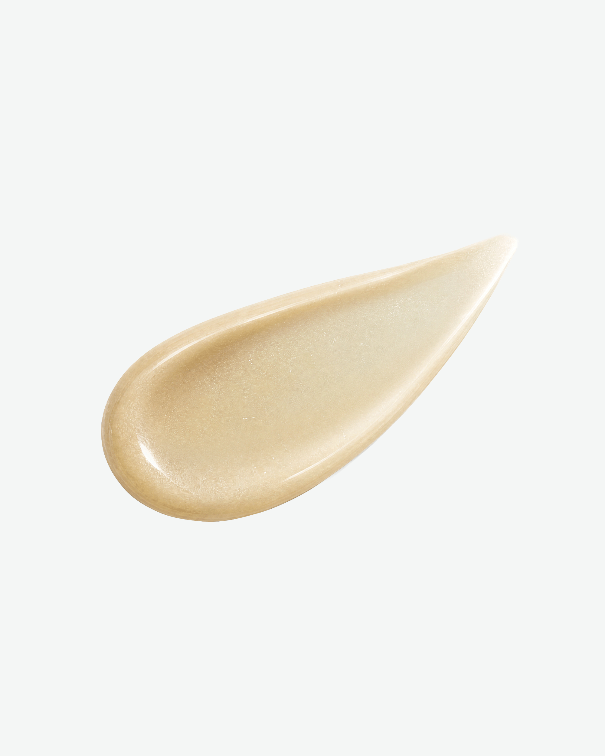 A teardrop-shaped smear of shimmering champagne beige cosmetic cream on a clean white background.