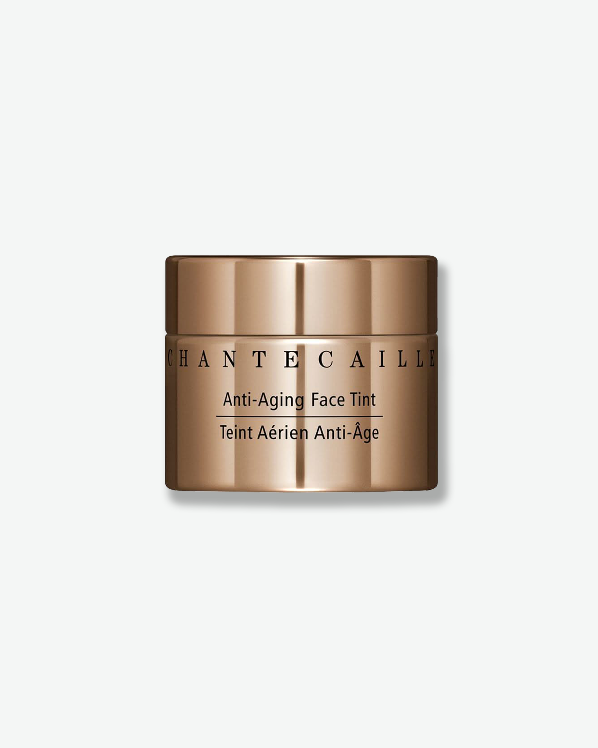 Front view of a Chantecaille Anti-Aging Face Tint jar against a plain gray background. The cylindrical cosmetic jar features a reflective, metallic bronze finish with the brand name and product title printed in black text.