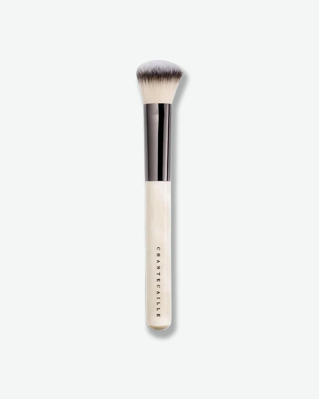 Makeup brush with a white handle on a light beige background