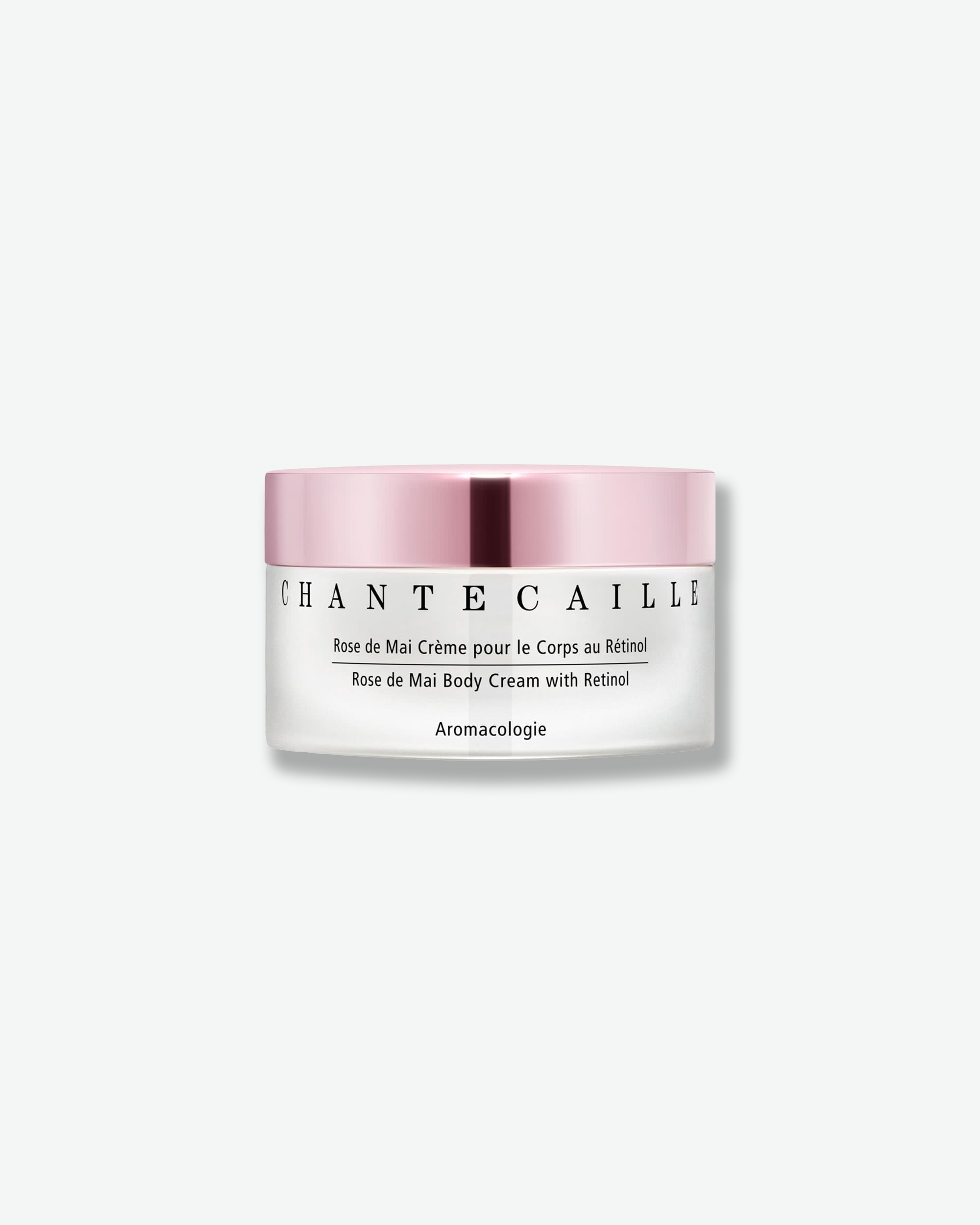 Front view of a Chantecaille Rose de Mai Body Cream with Retinol jar against a plain gray background. The wide, frosted white glass jar features black text branding and is paired with a contrasting, reflective metallic rose pink cap.