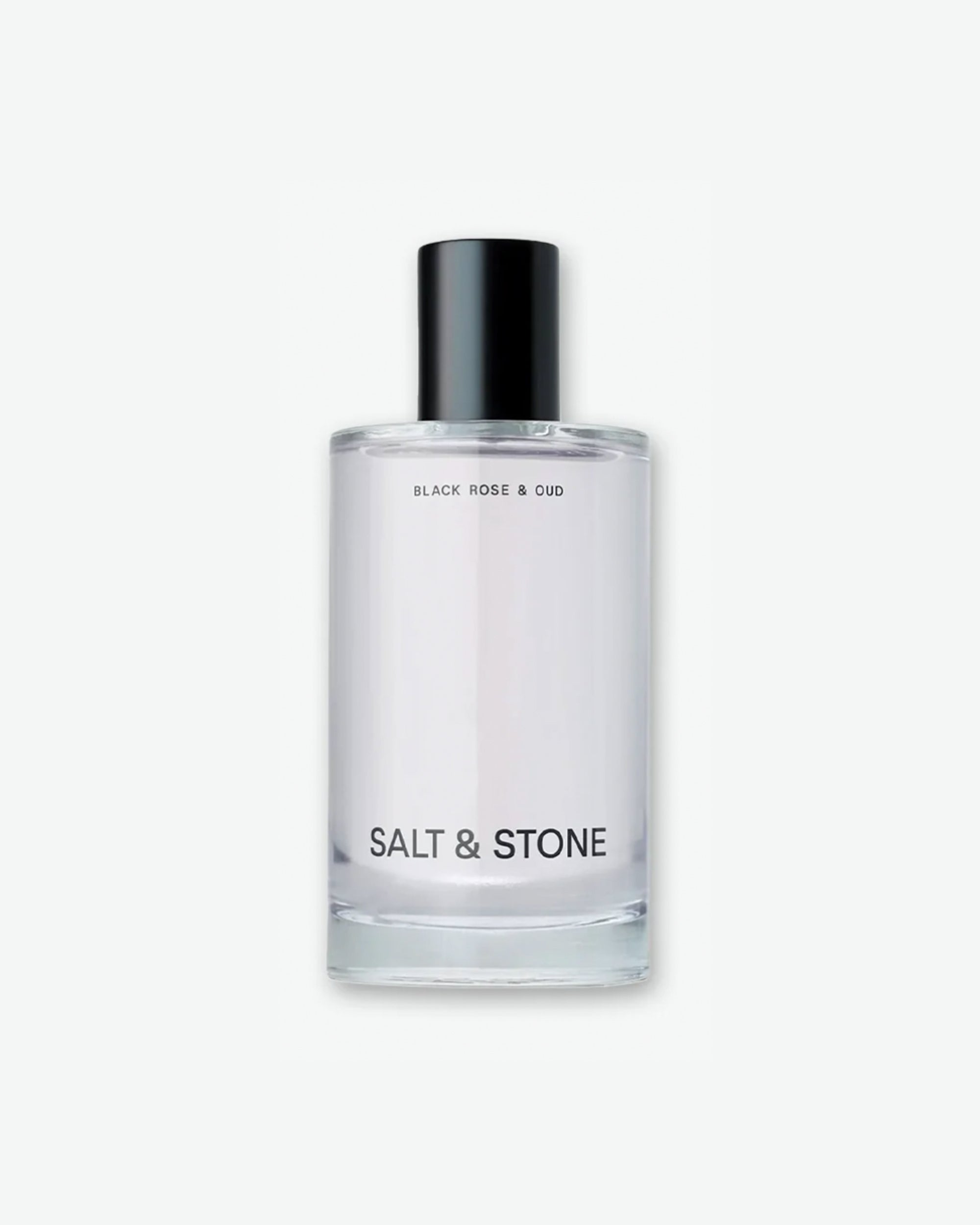 A studio product shot of Salt & Stone Black Rose & Oud Body Mist. The minimalist clear glass cylindrical bottle features a black atomiser cap, with 'BLACK ROSE & OUD' printed at the top and 'SALT & STONE' in bold black text at the bottom.