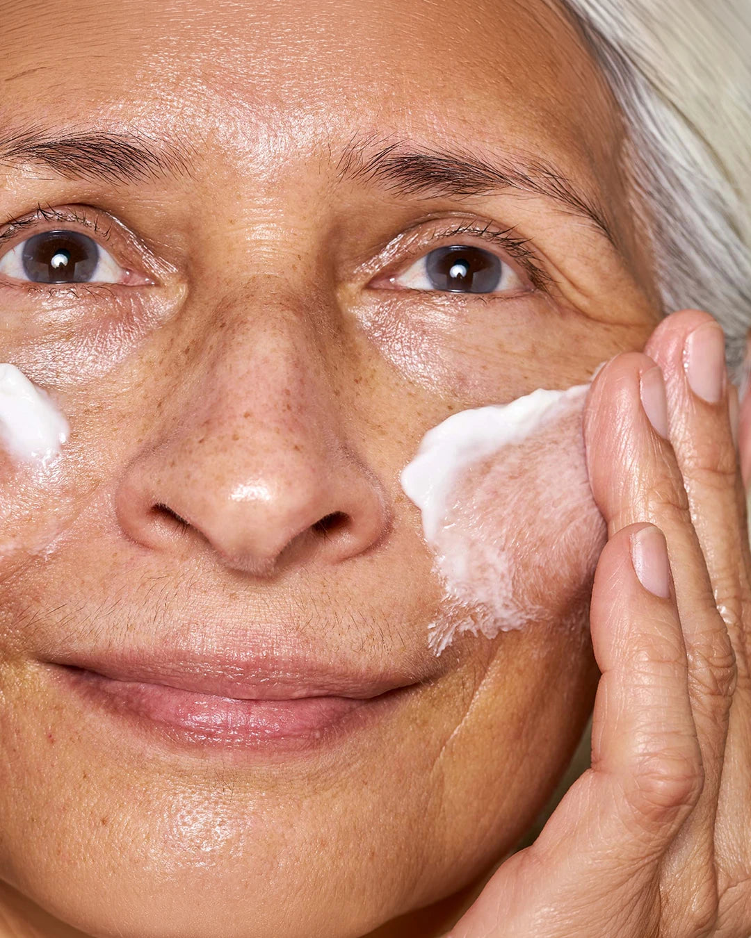 Close-up of a person applying cream to their face