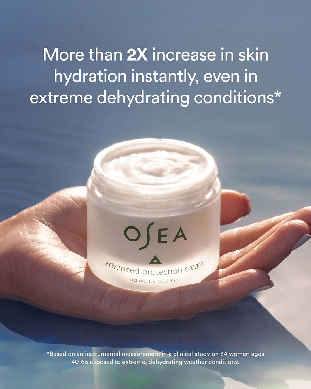 OSEA cream jar held in a hand with water background