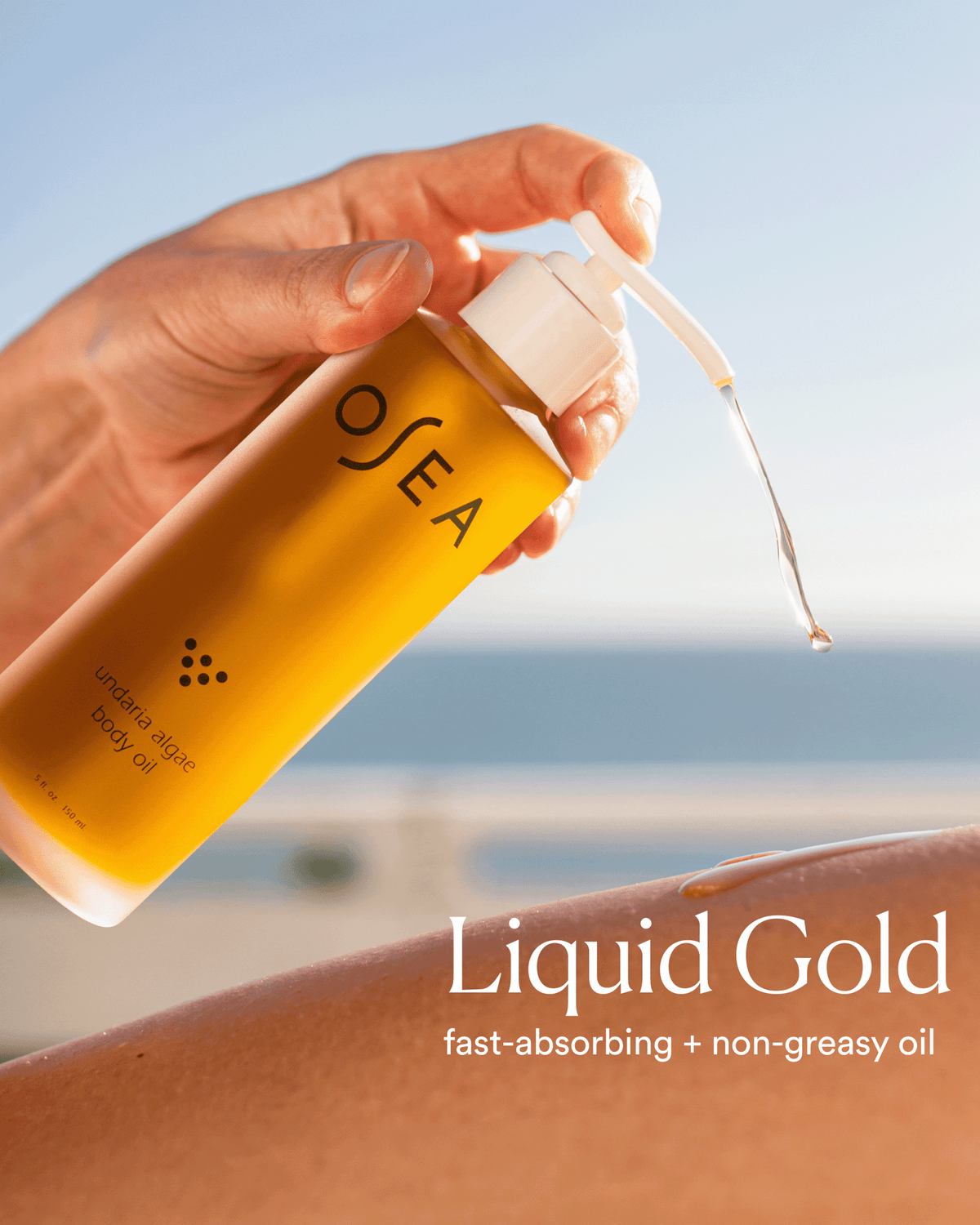 Close-up of OSEA Undaria Algae Body Oil being dispensed onto skin in a sunlit beach setting, highlighting its fast-absorbing, non-greasy formula.