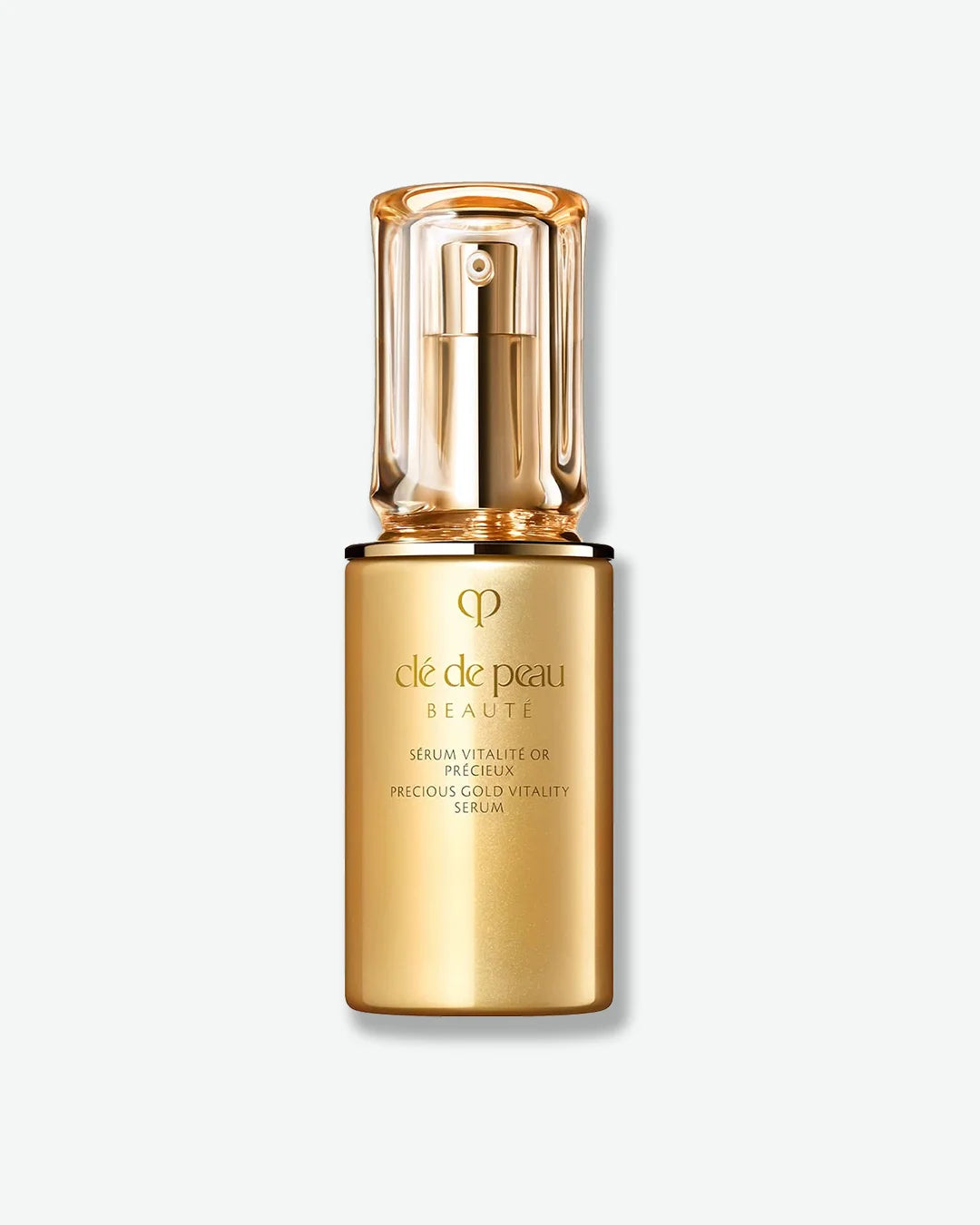 Gold serum bottle with 'clé de peau' branding on a white background
