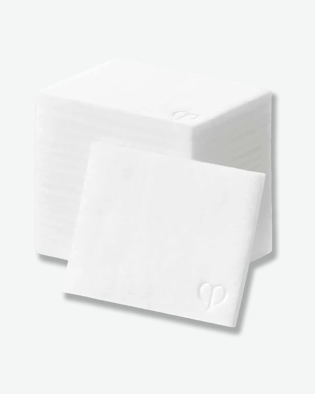 A stack of white square cotton pads with a soft, textured surface. One pad is positioned in front of the stack, showcasing its thin profile and embossed logo detail in the corner. Displayed against a light gray background.