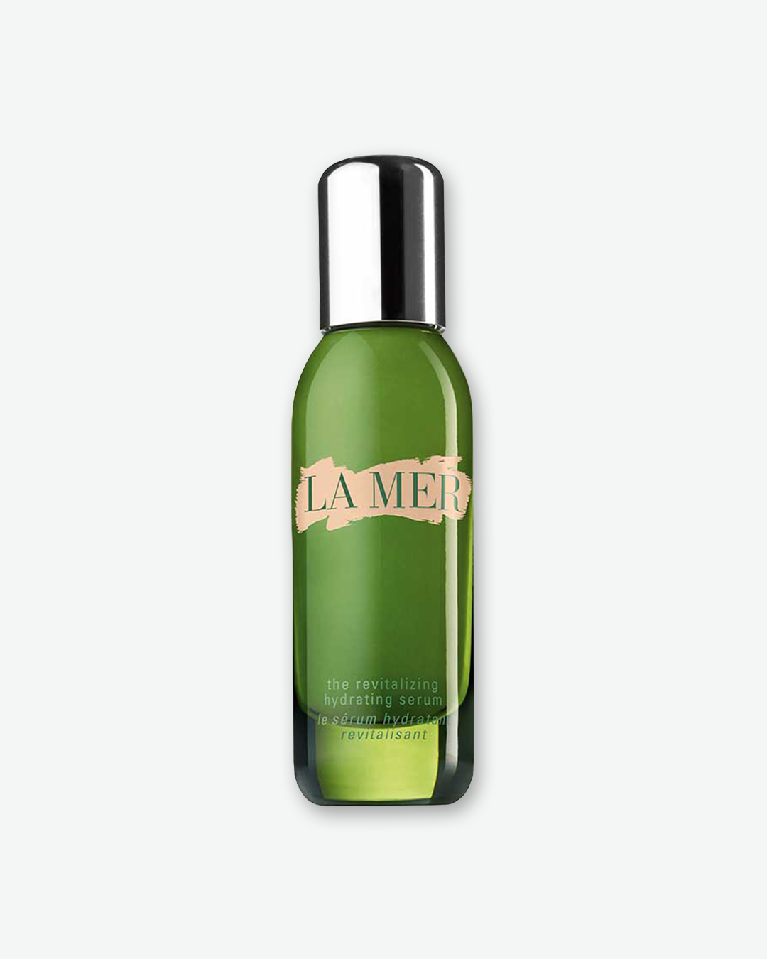 A product shot of a La Mer The Revitalizing Hydrating Serum bottle, centered against a plain light gray background. The slender cylindrical bottle is crafted from translucent grass-green glass, revealing the product inside, and is topped with a rounded, reflective silver pump cap. The front features the signature pale pink brushstroke background behind the green "LA MER" logo, with matching green text below outlining the serum details.